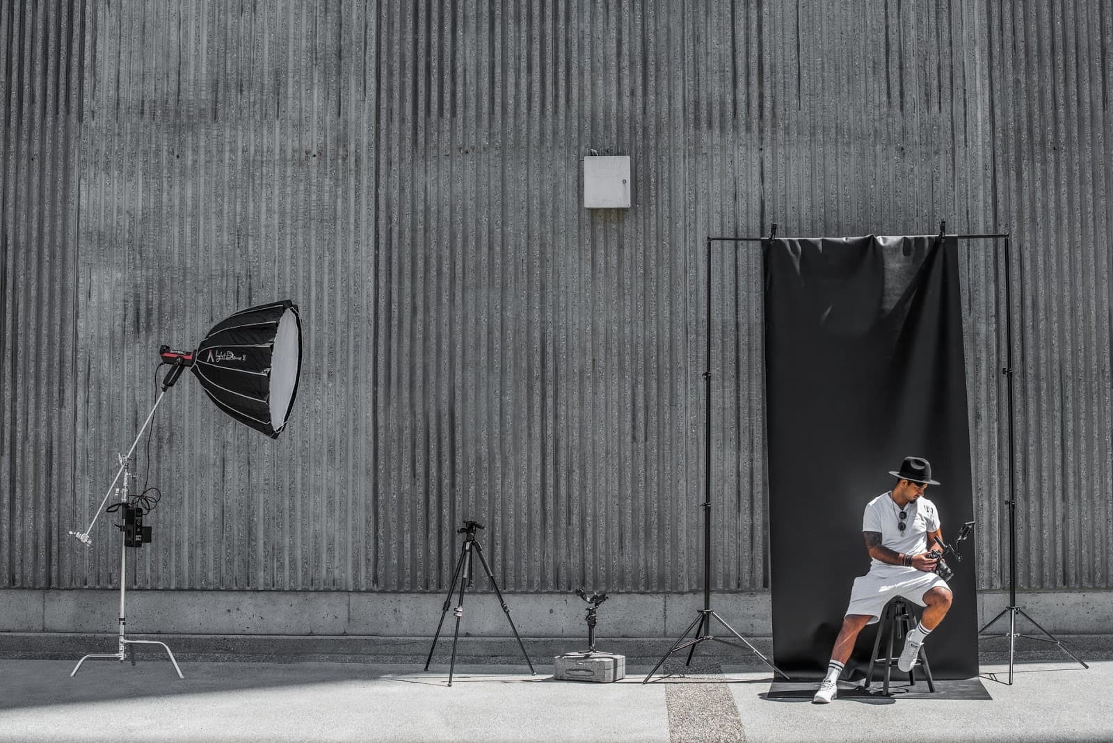 Outdoor photography setup with a softbox, tripod, and black backdrop