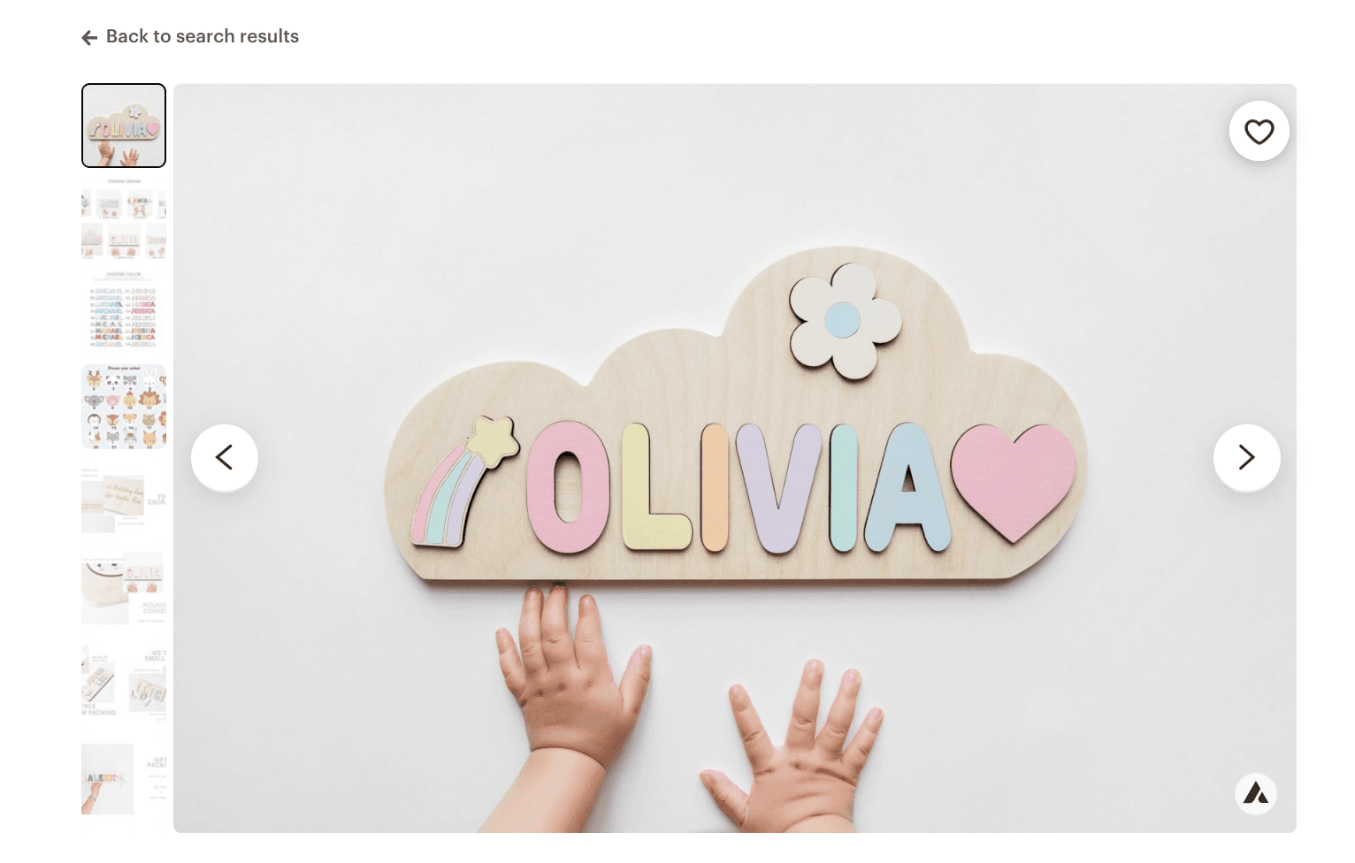 Personalized wooden name puzzle photographed on a white background with a child's hands