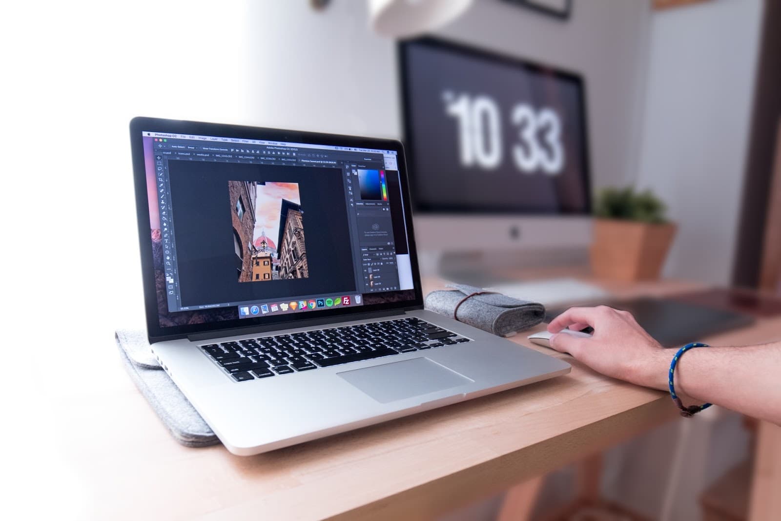 Person editing an architectural photo in Photoshop on a laptop