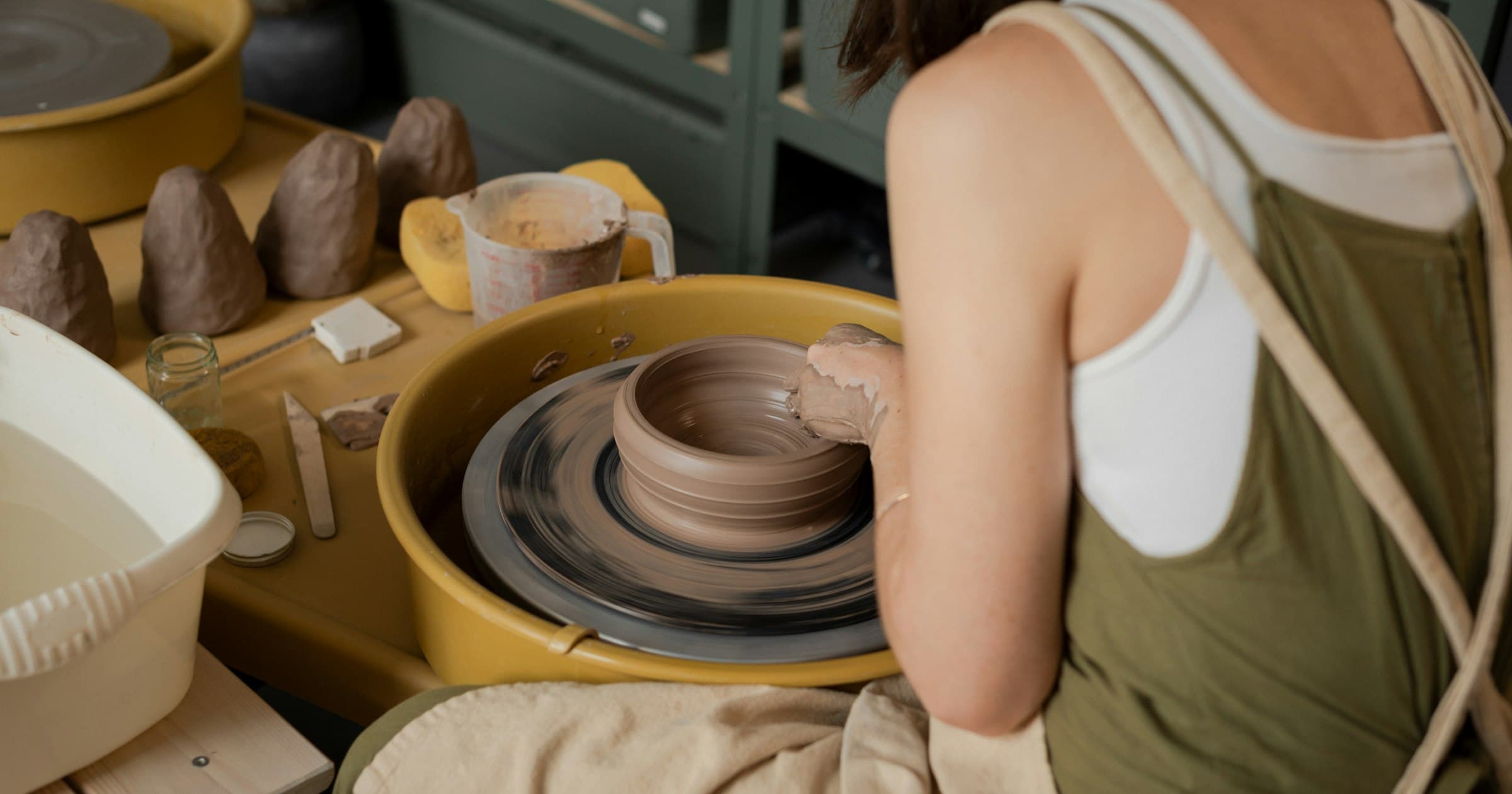 A potter shapes a bowl on the wheel