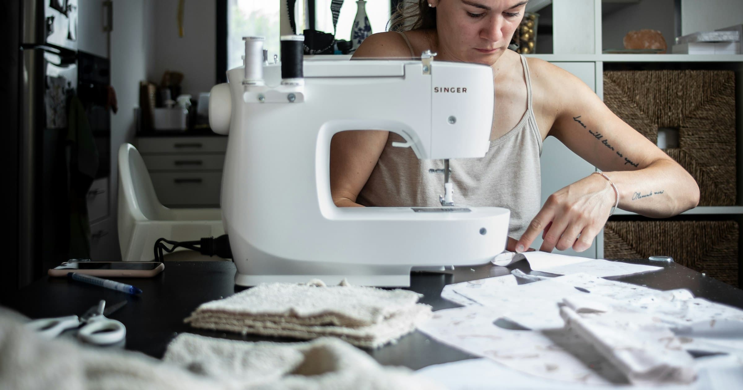 A maker sews at her kitchen table